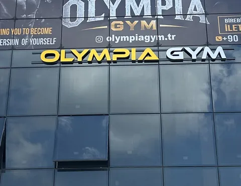 Özer Plaza'nın cam cephesindeki ışıklı Olympia Gym tabelası
